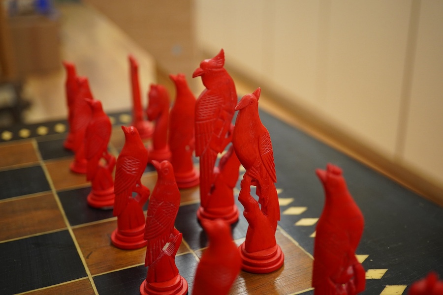 A Sri Lankan chess table and a boxed bone chess set, table measures 62cm high. Condition - good